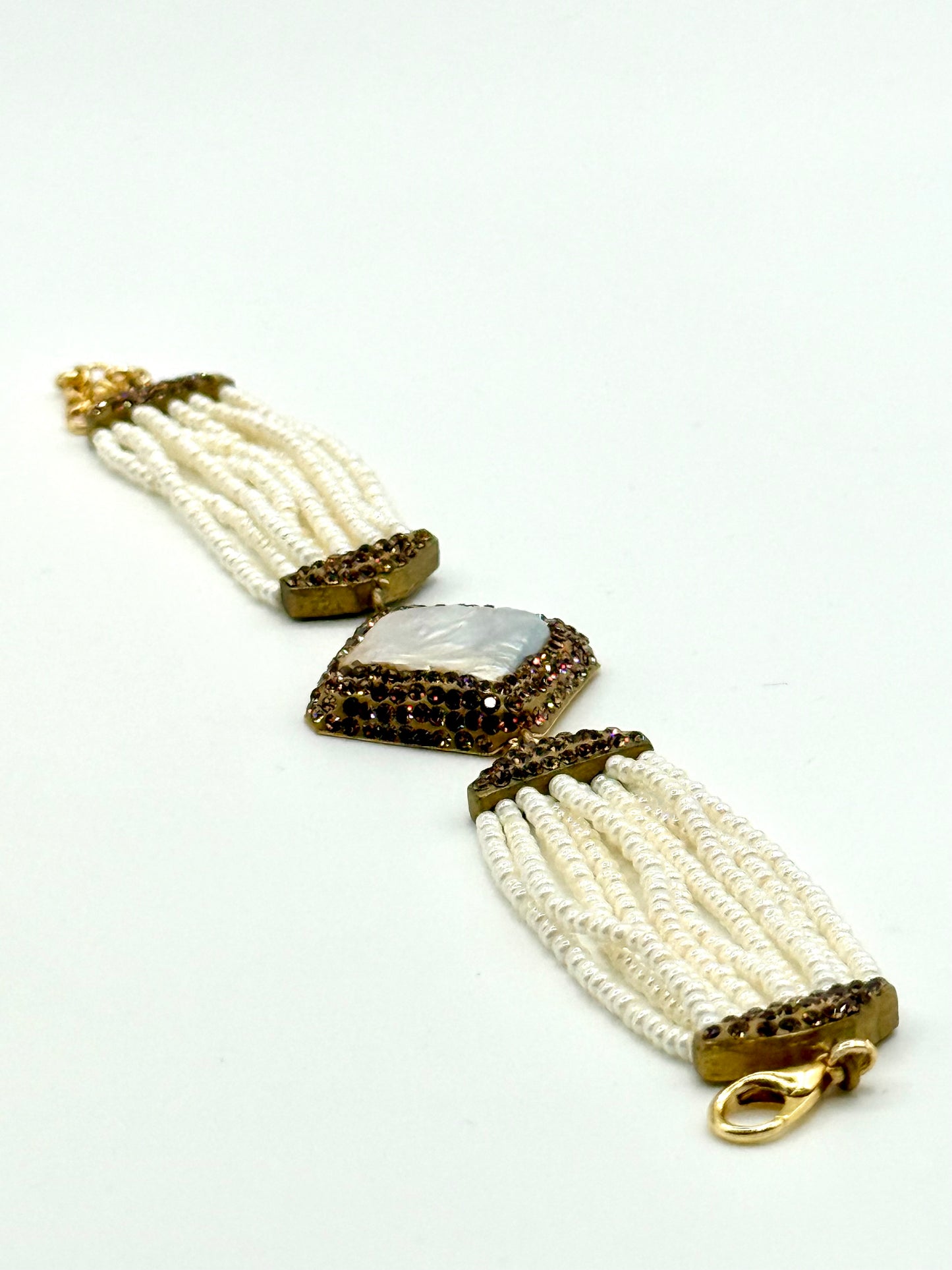 Pair of beaded earrings with gold and brown accents on a white background